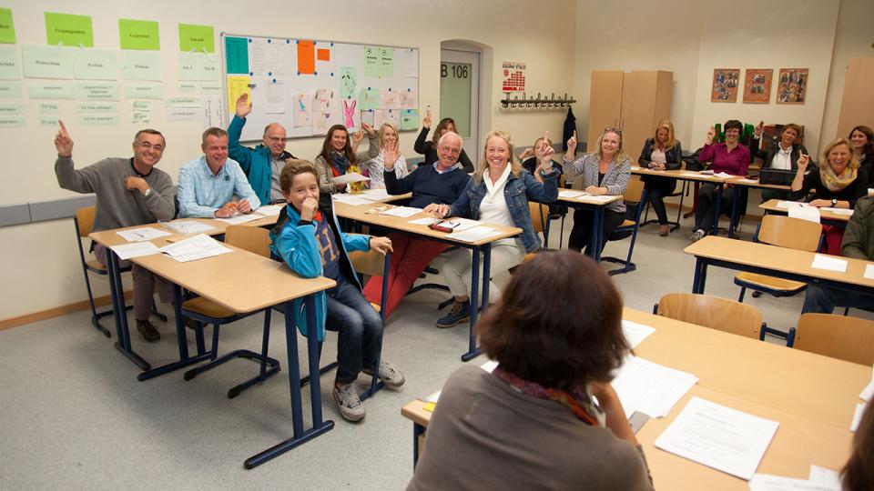 Treffen von Vertreterinnen und Vertretern der Elternverbände in einem Klassenzimmer